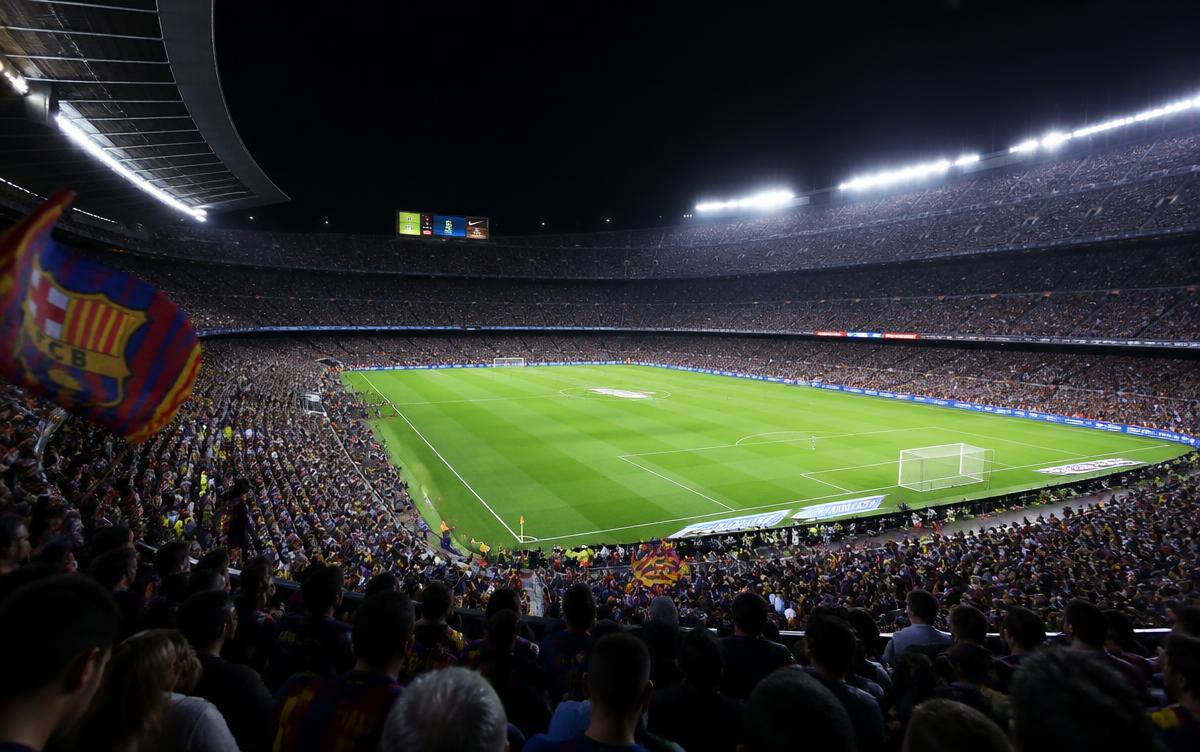 Stade de football plein la nuit sous les projecteurs